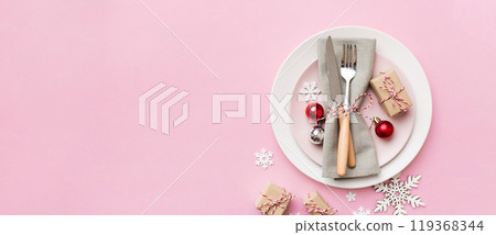 Christmas table place setting with christmas decor and plates, kine, fork and spoon. Christmas holiday background. Top view with copy space 119368344