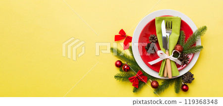 Christmas table place setting with christmas decor and plates, kine, fork and spoon. Christmas holiday background. Top view with copy space Christmas table place setting with christmas decor and plates, kine, fork and spoon. Christmas holiday background. Top view with copy space 119368348