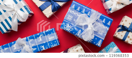 A lot of Christmas gift boxes in colored paper decorated on table, Top view close up. Many present New Year gift 119368353