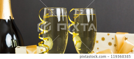 Champagne bottle with confetti, glasses and christmas decor on colored holiday background. Flat lay New Year decorations 119368385