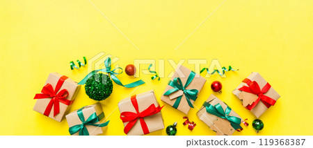 wrapped christmas or other holiday handmade present in paper with colored ribbon. Present box, decoration of gift on colourfull table, top view with copy space 119368387