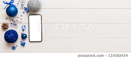 Digital phone mock up with rustic Christmas decorations for app presentation top view with empty space for you design. Christmas online shopping concept. Tablet with copy space on colored background 119368434