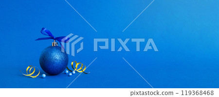 Christmas ball on colored background. decoration bauble with ribbon bow with copy space 119368468