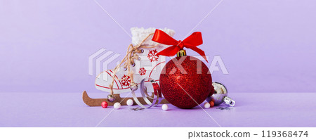 Christmas ball with skates on colored background. decoration bauble with ribbon bow with copy space 119368474