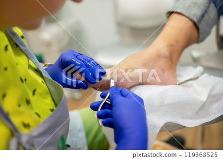 concept of male pedicure, cosmetologist makes classic pedicure for an elderly male client. 119368525