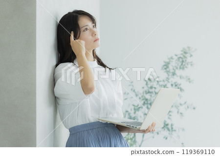 A woman using a computer with worries 119369110