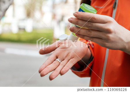 A woman applies an antibacterial antiseptic hand gel to disinfect and clean her hands. Close up of hands. Concept of influenza virus, coronavirus epidemic and infectious diseases 119369226