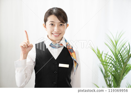 A woman who raises her index finger and smiles A woman who raises her index finger and smiles 119369956