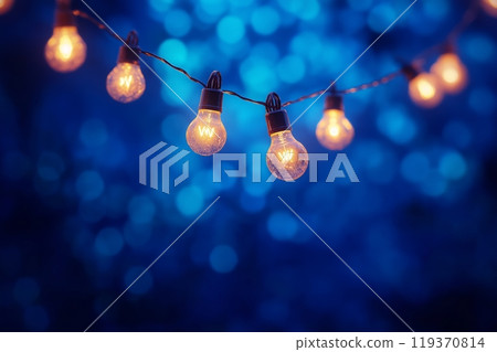 Glowing lights hung against a deep blue background, offering a warm festive atmosphere 119370814