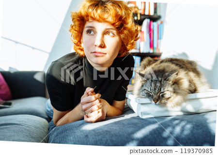 portrait red-haired attractive young woman with fluffy big cat 119370985