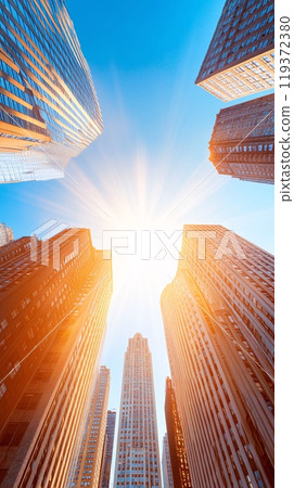 Vertical View of New York Skyscrapers with Radiant Sunburst and Blue Sky Vertical View of New York Skyscrapers with Radiant Sunburst and Blue Sky 119372380