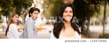 Jealousy. Jealous Girlfriend Calling Boyfriend Distracted By Other Attractive Woman Walking During Date In Park. Selective Focus Jealousy. Jealous Girlfriend Calling Boyfriend Distracted By Other Attractive Woman Walking During Date In Park. Selective Focus 119372698