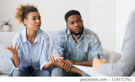 Couples Therapy Session. African American Wife Talking To Counselor Sitting On Sofa Next To Husband. Selective Focus 119372761