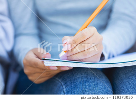 Cropped of student girl taking notes, studying with friends, using notepad and pencil Cropped of student girl taking notes, studying with friends, using notepad and pencil 119373030