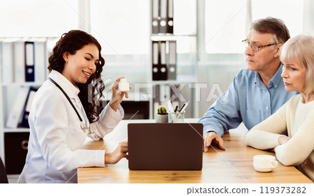 Alzheimer. Mexican doctor showing pills and diagnosis on tablet to mature couple, free space, panorama 119373282