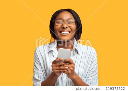Good New. Happy Afro Woman Holding Smartphone Standing Over Pink Background. Studio Shot 119373322