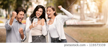 Three Joyful Friends With Cellphone Shaking Fists Celebrating Victory In Online Lottery Walking Outdoor. Great News Concept 119373339