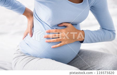 Pregnant woman having abdominal and back aches in the last trimester of pregnancy Pregnant woman having abdominal and back aches in the last trimester of pregnancy 119373820