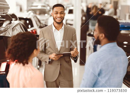 Car Sales Business. Auto Dealer Manager Talking With Couple Clients Selling Automobile In Dealership Store. Selective Focus 119373830