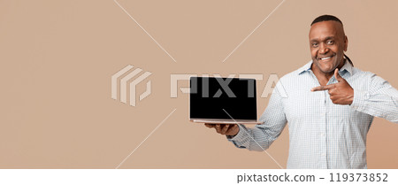 Awesome website. Middle aged positive afro man pointing at blank screen of laptop, orange studio background Awesome website. Middle aged positive afro man pointing at blank screen of laptop, orange studio background 119373852