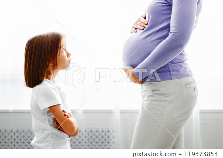Little daughter looking at her expecting mother with reproach, side view, close up Little daughter looking at her expecting mother with reproach, side view, close up 119373853