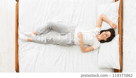 Bedtime. Millennial woman sleeping in bed, panorama, top view Bedtime. Millennial woman sleeping in bed, panorama, top view 119373862