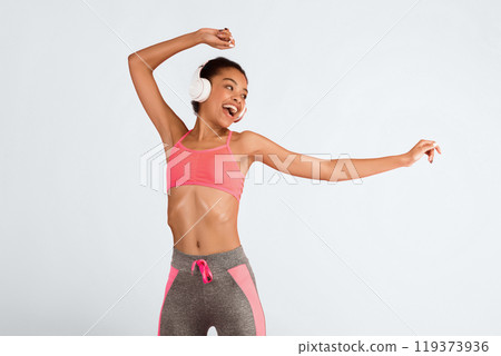Fitness And Music. Happy African American Girl In Headphones Dancing Over Pink Background. Studio Shot 119373936