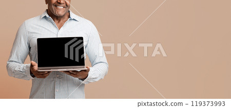 Modern lifestyle for old people. Mature african man showing blank screen of laptop, orange studio background Modern lifestyle for old people. Mature african man showing blank screen of laptop, orange studio background 119373993