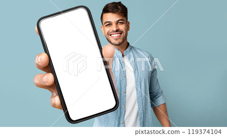 Smiling Handsome Arab Guy In Casual Showing Mobile Phone With White Blank Screen For Advertisement, Recommending Mobile Dating Application, Panorama With Free Space, Mockup, Colllage 119374104