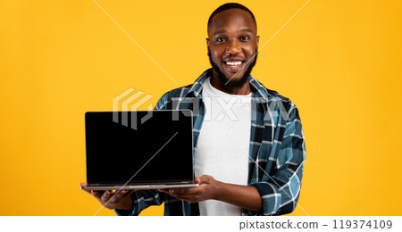 Smiling African Guy Showing Laptop Computer Blank Screen To Camera Recommending Great Website Standing On Yellow Studio Background. Online Service Advertisement. Mockup Smiling African Guy Showing Laptop Computer Blank Screen To Camera Recommending Great Website Standing On Yellow Studio Background. Online Service Advertisement. Mockup 119374109