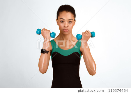 Workout Concept. Serious Black Girl Doing Dumbbell Bicep Curls Pumping Muscles Over Yellow Background In Studio 119374464