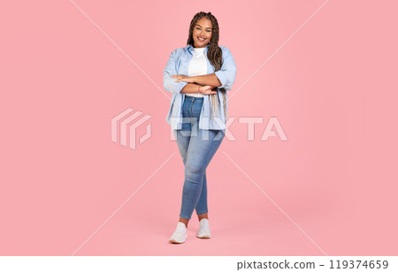 Attractive African American Female Posing Wearing Plus Size Clothes, Standing Crossing Hands And Smiling To Camera On Pink Background In Studio. Body Positive Concept. Full Length Shot 119374659