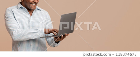 Technology and retiree. Mature african man typing on laptop, orange panorama background Technology and retiree. Mature african man typing on laptop, orange panorama background 119374675