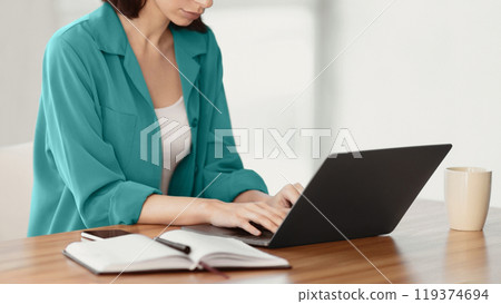 Time To Work. Unrecognizable focused girl sitting at desk in modern office using laptop, writing report, copyspace Time To Work. Unrecognizable focused girl sitting at desk in modern office using laptop, writing report, copyspace 119374694