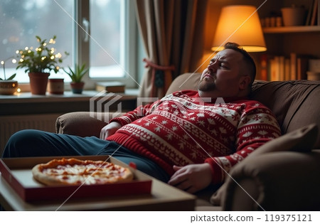 Sad overweight man sitting with a box of pizza on new year's eve, christmas 119375121