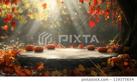 A tranquil woodland area features a stone platform surrounded by colorful autumn leaves and small pumpkins. Sunlight filters through the trees, casting a warm glow on this picturesque scene. 119375654