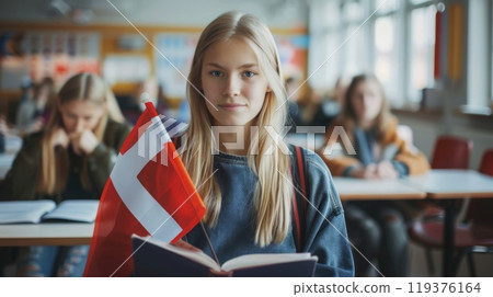 A student in a classroom reads a book while proudly displaying a Norwegian flag, surrounded by classmates engaged in their studies. 119376164
