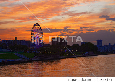 Arakawa Amusement Park's Ferris wheel and the scenery reflected in the Sumida River. Evening scenery, sunset, night view, light-up Arakawa Amusement Park's Ferris wheel and the scenery reflected in the Sumida River. Evening scenery, sunset, night view, light-up 119376173