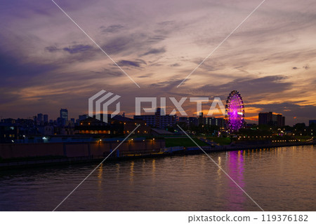 Arakawa Amusement Park's Ferris wheel and the scenery reflected in the Sumida River. Evening scenery, sunset, night view, light-up 119376182