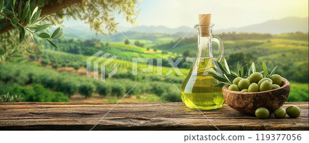 Bottle of olive oil, bowl of freshly harvested olives on old wooden table, Italian landscape with olive trees, copy space 119377056