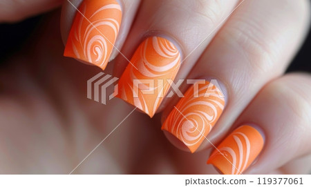 Close-up of a hand with orange nails featuring a swirl design. 119377061