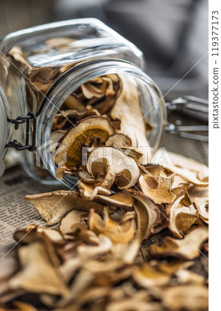 Dried porcini mushrooms. Sliced boletus in jar on wooden table. 119377173