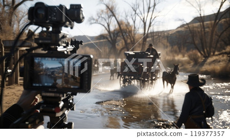 Crew captures a western scene featuring a horse-drawn carriage traversing a shallow stream on a sunny day. Crew captures a western scene featuring a horse-drawn carriage traversing a shallow stream on a sunny day. 119377357