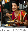 Beautiful Indian woman smiling and eating 119378565