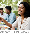 Smiling Indian woman eating 119378577