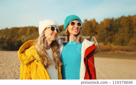 Happy young two women friends on sunny beach, stylish girlfriends smiles together on sea coast 119378686
