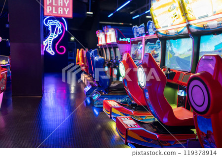 Empty gaming chairs in illuminated arcade game 119378914