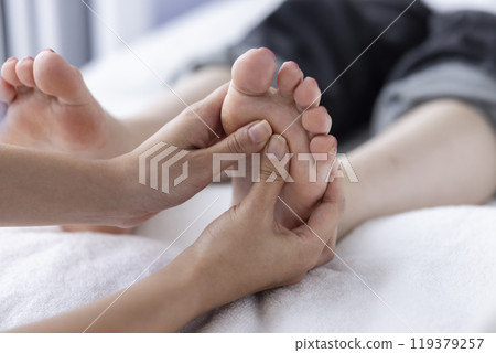 A woman receiving a foot massage A woman receiving a foot massage 119379257