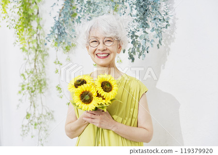 Senior woman holding sunflowers Senior woman holding sunflowers 119379920