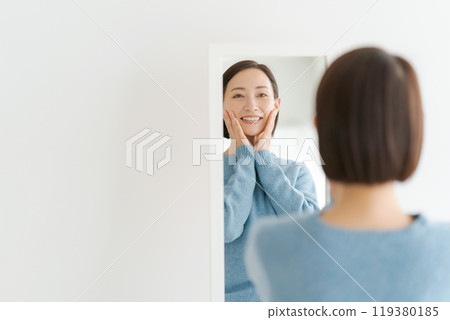 40多歲的女人照鏡子微笑 119380185